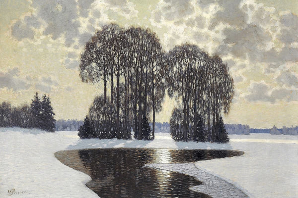 A group of bare winter trees stands behind an open stream in a flat, snow-covered landscape under a cloudy sky.