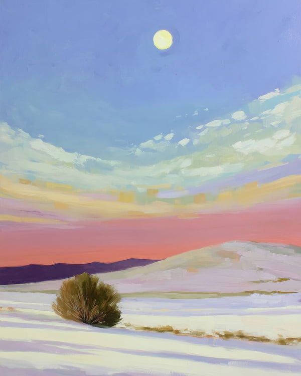 A lone desert shrub sits among white sand dunes at twilight, with a full moon in a blue sky above a pink sunset horizon and d