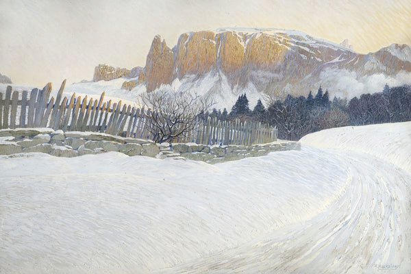 A snow-covered winding road beside a wooden fence and stone wall leads toward towering ochre mountain cliffs under a pale win